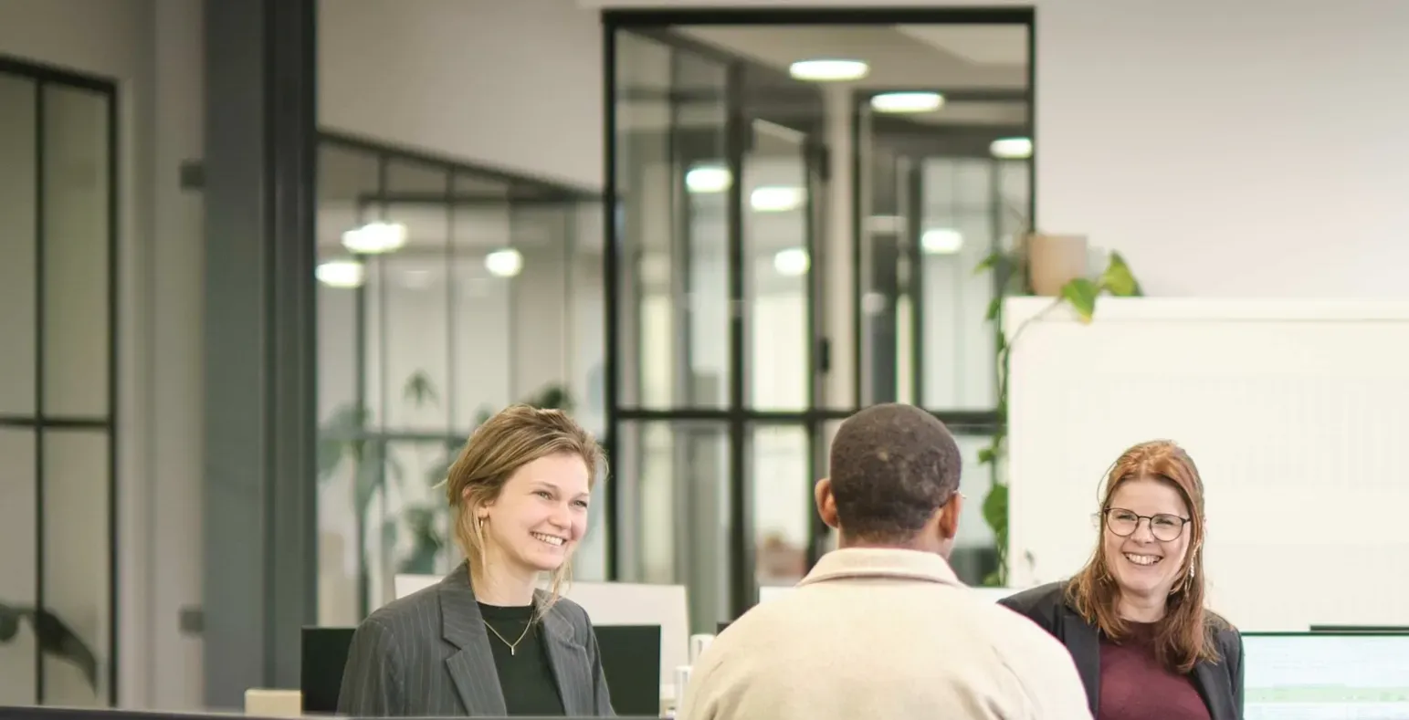 drie collega's op kantoor in overleg